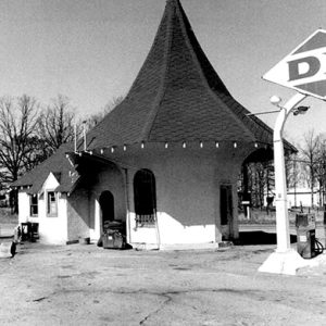 Small gas station with cone shaped roof and sign