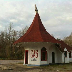 Abandoned gas station with cone shaped roof and street