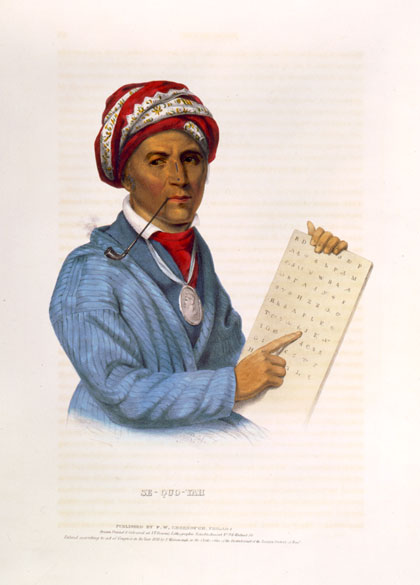 Native American man in a turban with a pipe holding a tablet with letters on it