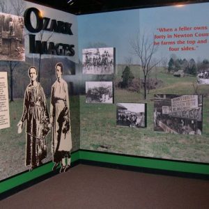 Exhibition display "Ozark Images" with rural background  captions attached photographs and women figures in dresses