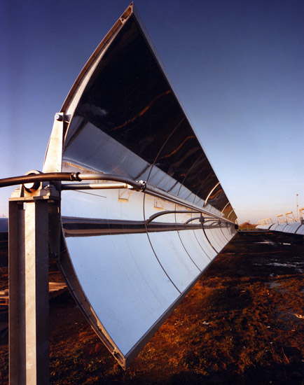 Close-up view of row of curved solar panels in field