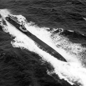 Aerial photo of submarine in ocean making large waves