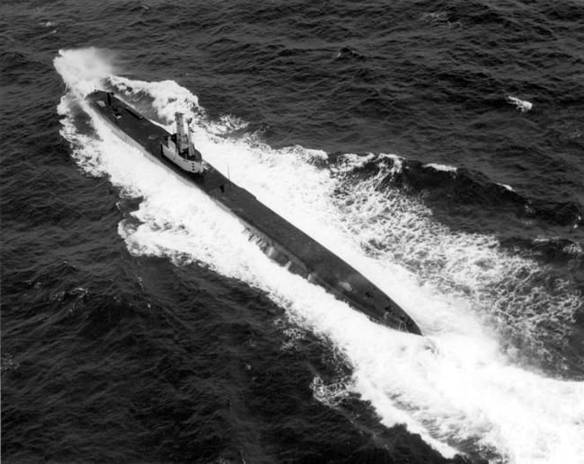 Aerial photo of submarine in ocean making large waves