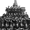 Uniformed Navy group photo atop docked submarine
