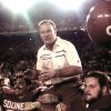 White football coach hoisted on "Sooners" players shoulders  with stadium crowd in background