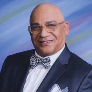 Bald African-American man with glasses in suit and bow tie
