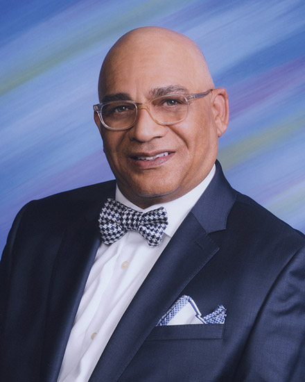 Bald African-American man with glasses in suit and bow tie