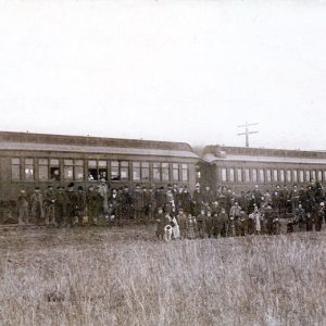 Group of people posing with train cars at depot