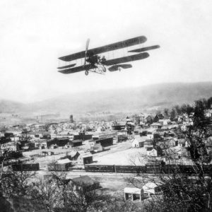 Biplane flying over a small town