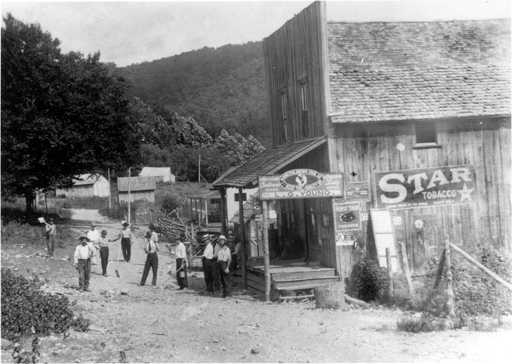 Group of men with digging tools outside the "L. G Young" store