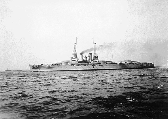 Battleship from distance with chimney smoke on choppy water