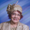 Older African-American woman smiling in hat and suit