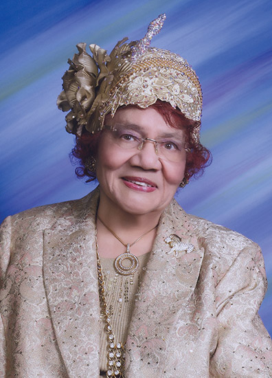 Older African-American woman smiling in hat and suit