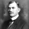 white man with mustache in suit and tie