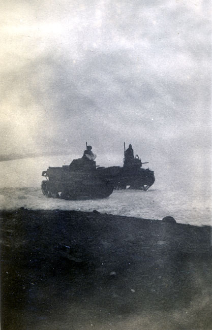 Two tanks with gunners driving on snow