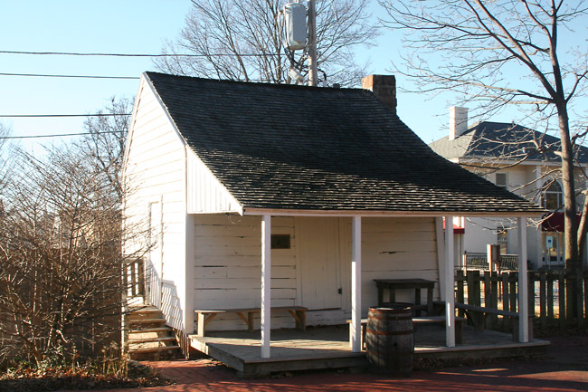 small old whitewashed wooden building with front porch