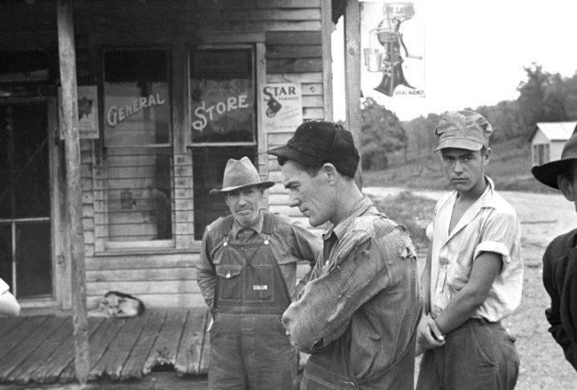 some men in working clothing outside wooden building "General Store"