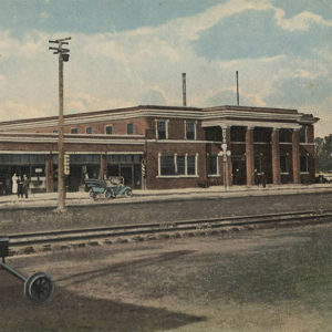 One and two story brick buildings beside railroad tracks