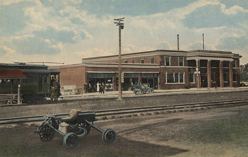 One and two story brick buildings beside railroad tracks