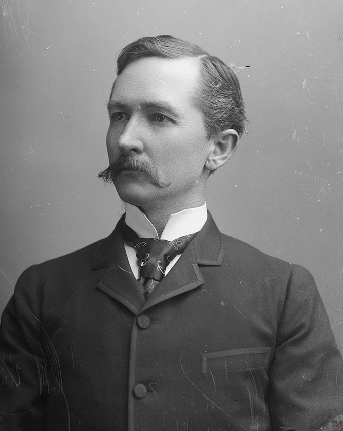 White man in suit and tie with mustache
