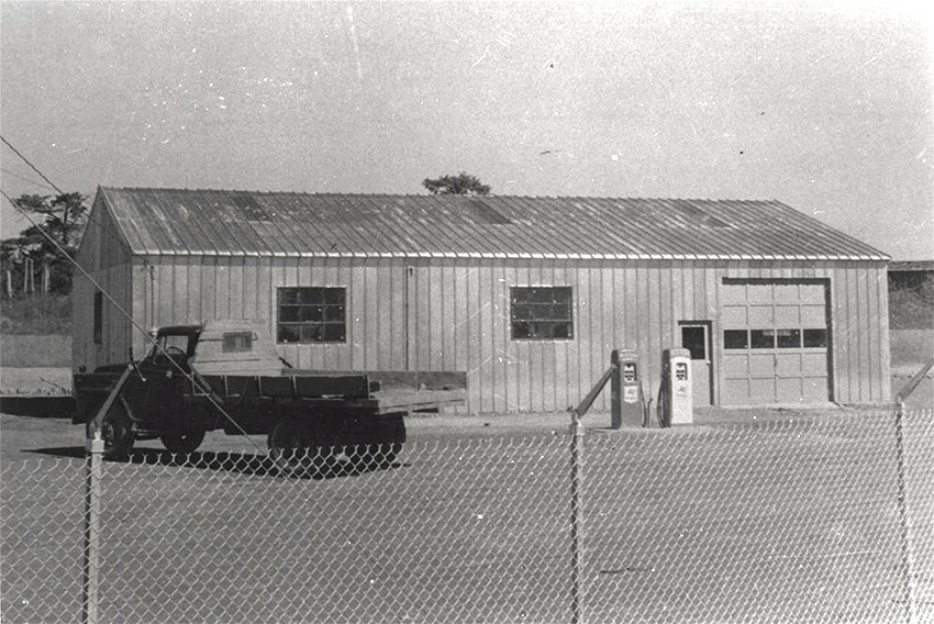 Truck in front of metal building with single bay and windows