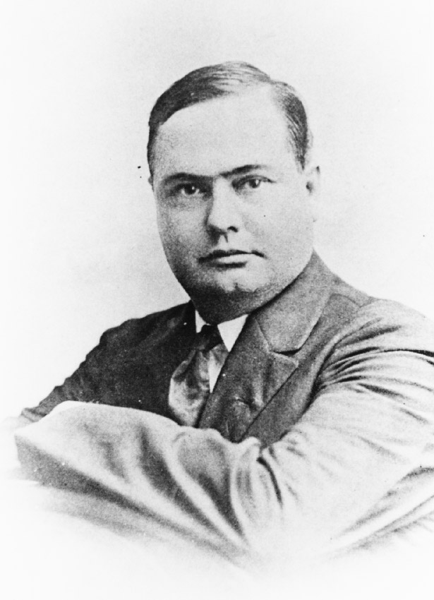Head and shoulders portrait of white man wearing suit and tie