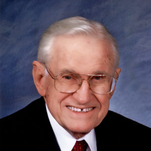 Older white man in suit and tie with glasses