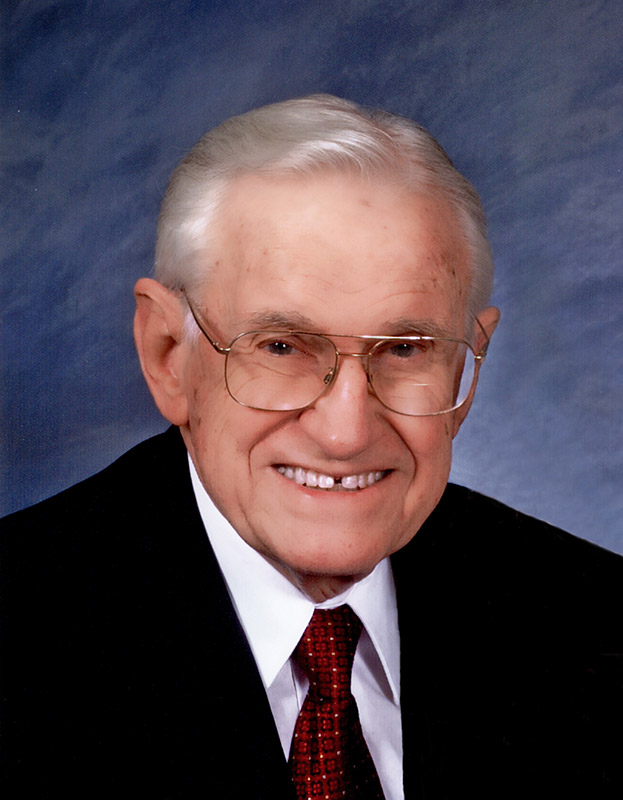 Older white man in suit and tie with glasses