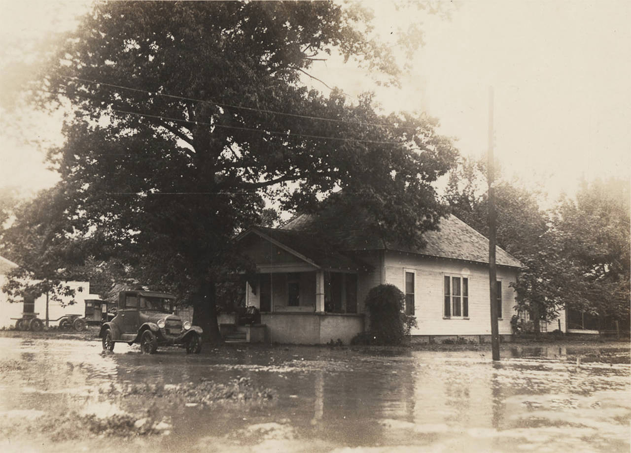 Car and house in flood waters