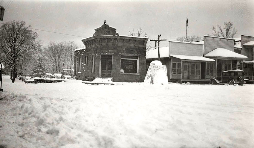 Storefront buildings with street and awnings covered in snow