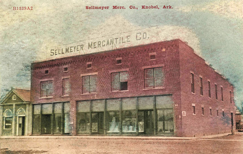 Two story red brick building with sign saying "Sellmeyer Mercantile  Company"