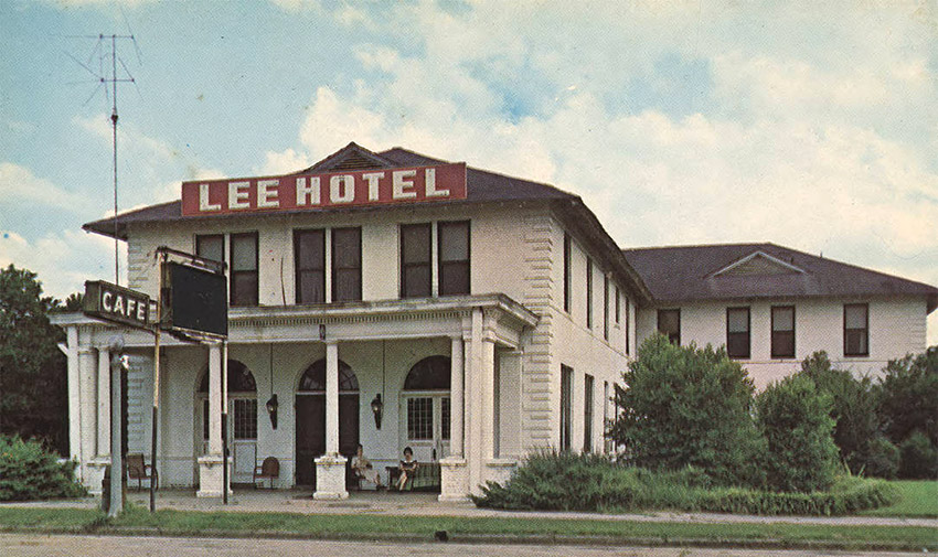Two story white building "Lee Hotel" and "Cafe"