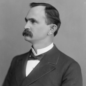 White man in suit with mustache