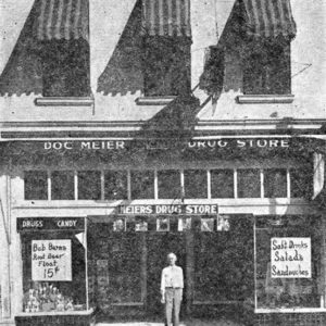 Man standing in front of two story building with striped awnings