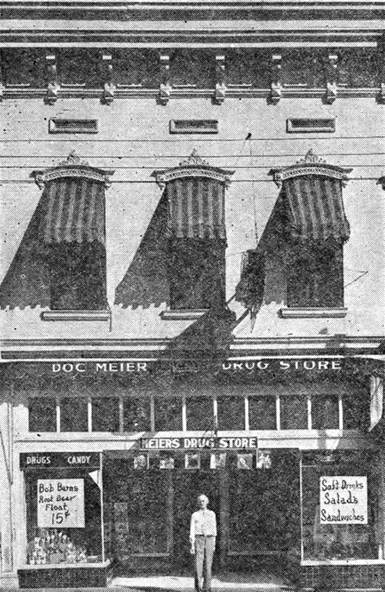 Man standing in front of two story building with striped awnings