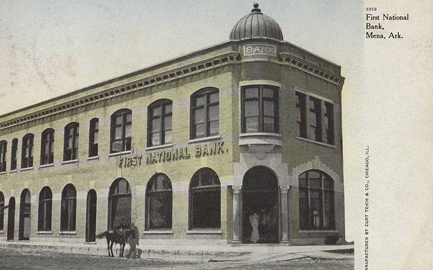 Two story building with dome over entrance and horse standing at sidewalk