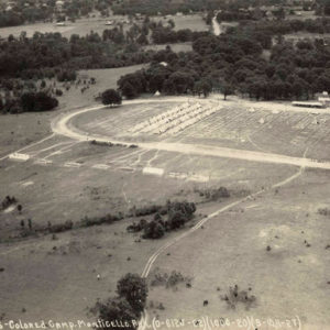 Aerial view of white tents set up in rows on oval racetrack