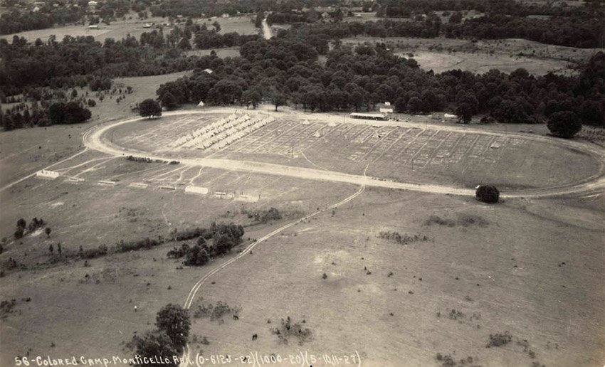 Aerial view of white tents set up in rows on oval racetrack