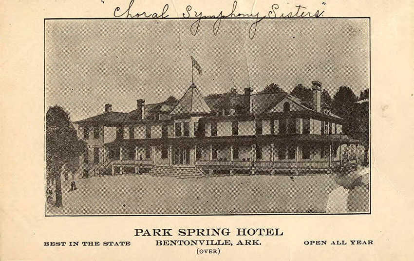 Multistory building with cupola featuring flagpole and flag; postcard has printed on it "best in state" and "open all year"
