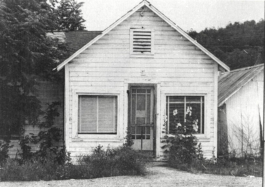 Wooden white building with front door and front facing windows