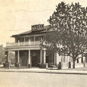 two story brick building with covered entrance with sign saying "Hotel Saxon"
