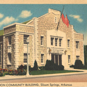 Multistory stone building with large America flag over entrance