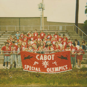 Group of people behind Cabot Special Olympics sign