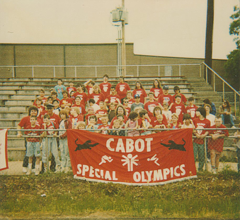 Group of people behind Cabot Special Olympics sign