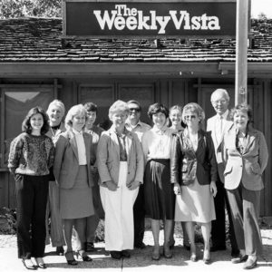 Large group of people standing in front of Weekly Vista building
