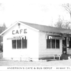 Single story white building with sign saying "Cafe"