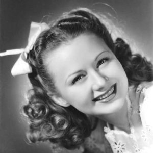 White teenager with bow in hair smiling