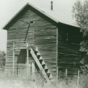 Multistory wooden building with wooden stairs and door on the side