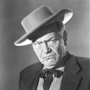 White man wearing flat brimmed hat and scowling