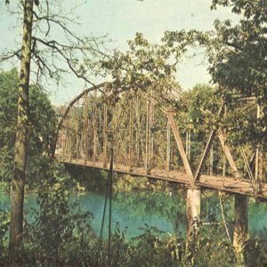 Bridge spanning river in woods